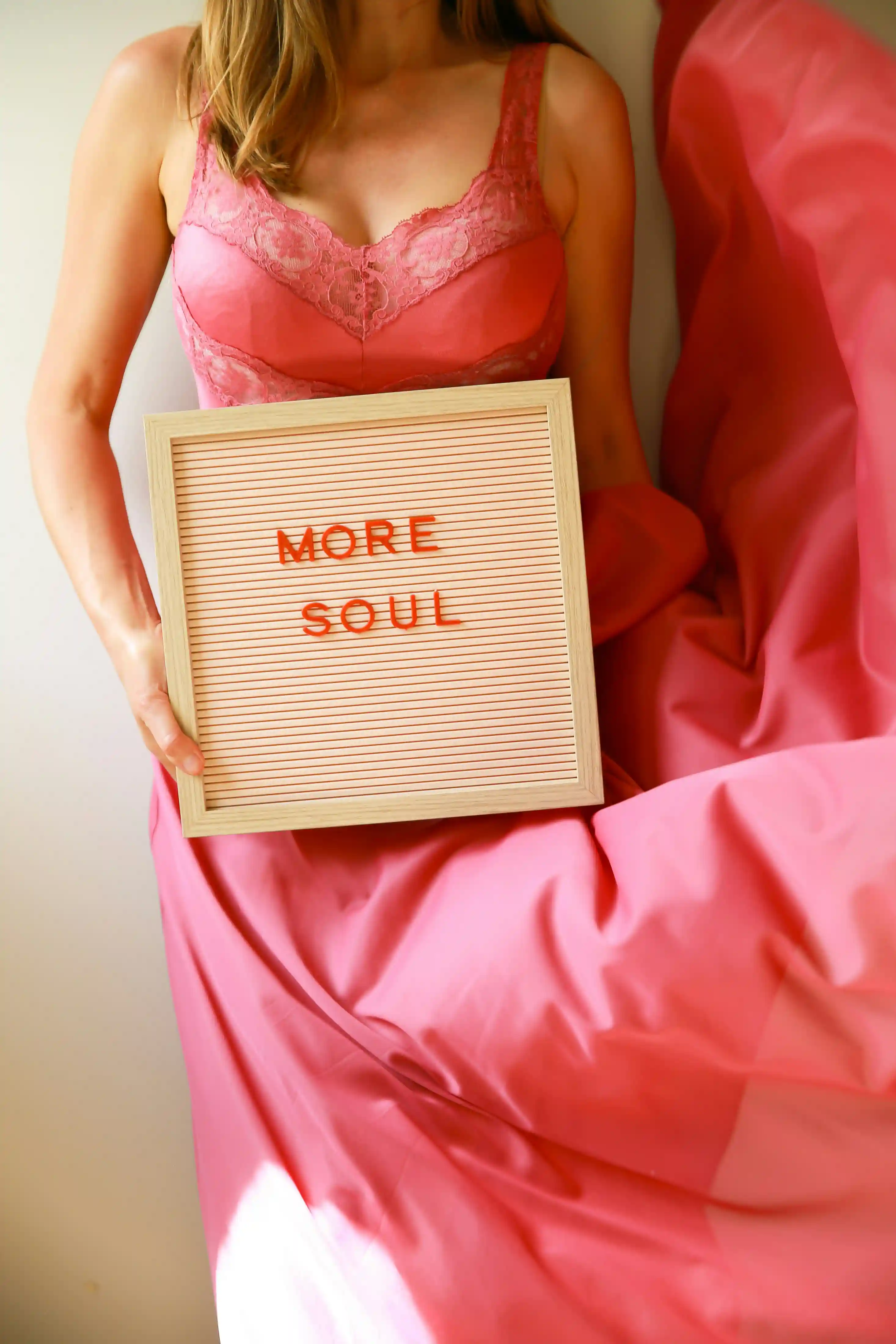 Женская фигура в розовом платье держит табличку «more soul». Общий смысл: душа и тело одно целое.